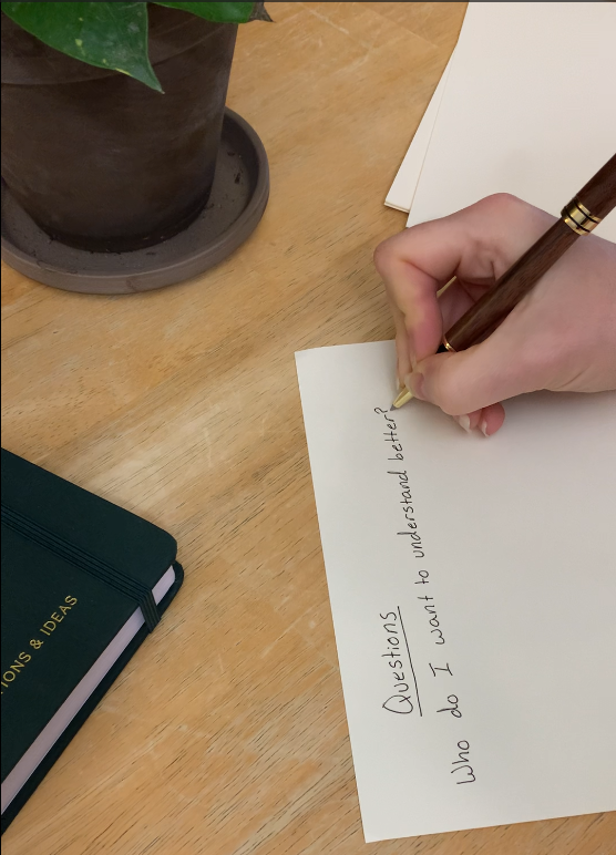 Hand writing genealogy research questions on paper