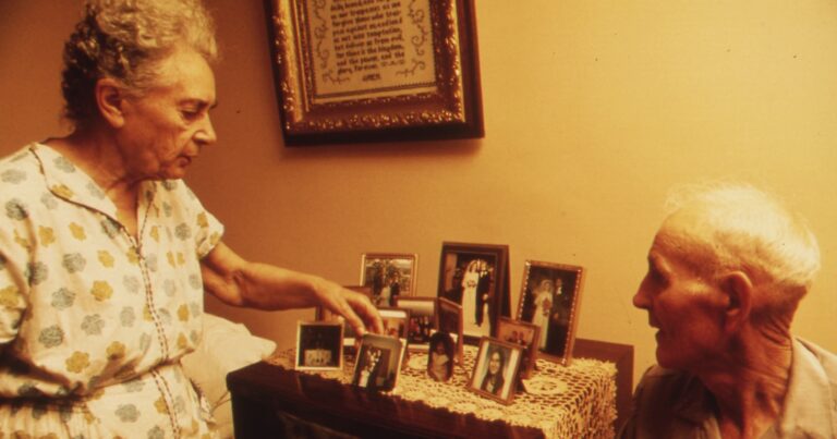 Vintage family photographs displayed on a table beneath a framed family document.